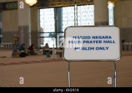 Un cartello all'ingresso della gralla di preghiera della Moschea Nazionale Masjid Negara, Kuala Lumpur Foto Stock