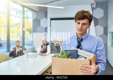 Ritratto di giovane triste in scatola di contenimento di oggetti personali di essere licenziato dal lavoro in azienda, spazio di copia Foto Stock