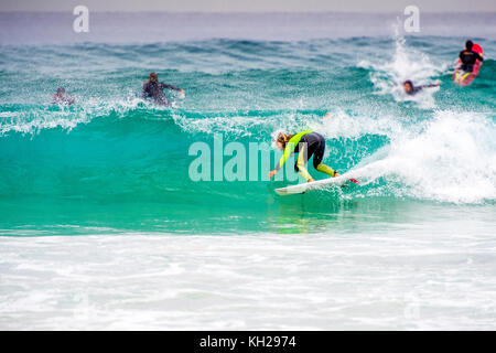 Un surfista cavalcare un onda a Sydney iconici Bondi Beach, NSW, Australia Foto Stock