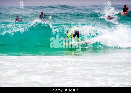 Un surfista cavalcare un onda a Sydney iconici Bondi Beach, NSW, Australia Foto Stock