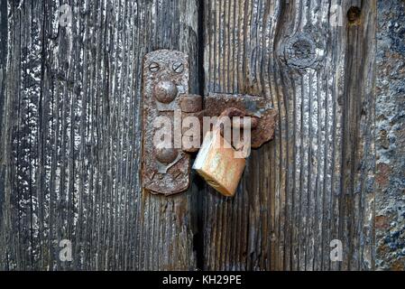 In prossimità di una serratura arrugginita su una vecchia porta di legno Foto Stock