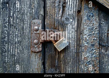 In prossimità di una serratura arrugginita su una vecchia porta di legno Foto Stock