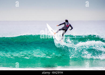 Un surfista cavalcare un onda a Sydney iconici Bondi Beach, NSW, Australia Foto Stock