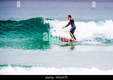 Un surfista cavalcare un onda a Sydney iconici Bondi Beach, NSW, Australia Foto Stock