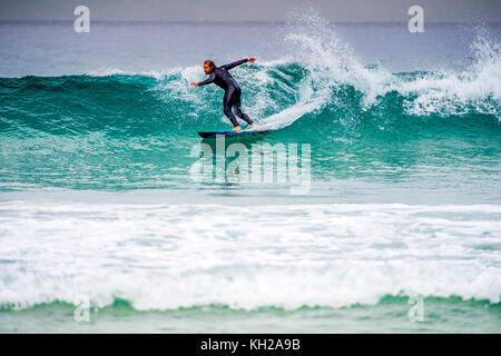 Un surfista cavalcare un onda a Sydney iconici Bondi Beach, NSW, Australia Foto Stock