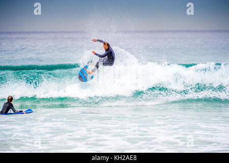 Un surfista cavalcare un onda a Sydney iconici Bondi Beach, NSW, Australia Foto Stock