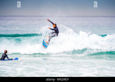 Un surfista cavalcare un onda a Sydney iconici Bondi Beach, NSW, Australia Foto Stock