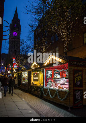 Mercatino di Natale bancarelle in cima brazennose Street, Manchester, UK e municipio orologio in background Foto Stock