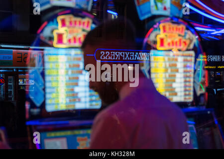 Un uomo gioca slot machines in una sala giochi a Chinatown in Soho nel West End di Londra, Regno Unito Foto Stock