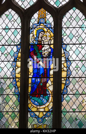 La Madonna e il bambino, dettaglio di una parte della macchia finestra vetrate nella Basilica di Santa Maria Vergine Chiesa Parrocchiale, Axminster, Devon, Inghilterra, Regno Unito nel mese di novembre Foto Stock