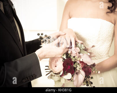 Lo sposo mette l' anello di matrimonio su la sposa del dito Foto Stock