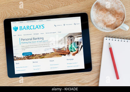 Sito web di Barclays funzioni su un iPad dispositivo tablet pc che si appoggia su una tavola di legno accanto a un blocco note e matita e una tazza di caffè (editoriale solo) Foto Stock
