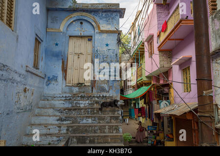 Vecchia città di Varanasi vicoletto con case d'epoca di pareti in mattoni e ripida scalinata. Foto Stock