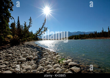 Una bella vista di un fiume canadese e le montagne con una svasatura di Sun Foto Stock