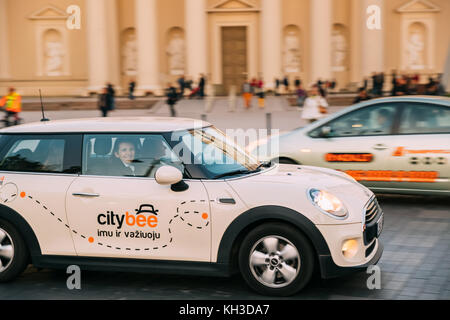 Vilnius, Lituania - 29 settembre 2017: colore bianco auto Mini Cooper con il logo citybee in movimento su strada con driver femminile. citybee company fornisce c Foto Stock