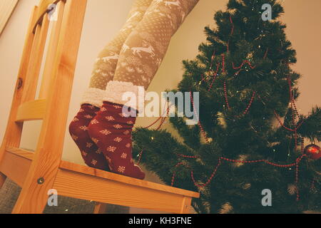 La decorazione di albero di natale in piedi su una sedia vista dal basso Foto Stock