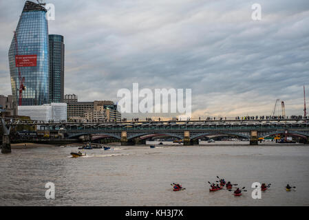 Canoisti sul Fiume Tamigi Londra avvicinando Millennium Bridge e Blackfriars con persone attraversando a piedi nella cortina di nubi meteo vicino al tramonto Foto Stock