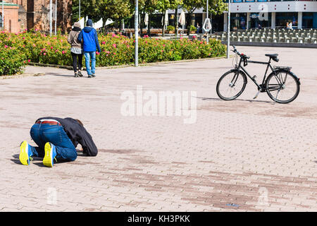 BERLINO, GERMANIA - 13 SETTEMBRE 2017: L'uomo scatta una foto di una bicicletta in piazza Alexanderplatz a Berlino nel mese di settembre. Alexanderplatz è un grande pubblico Foto Stock
