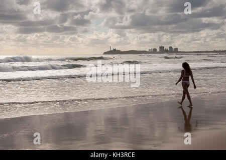 La mattina presto, una donna sola a camminare verso il surf in Alexandra Headland sulla Costa del Sole, Queensland, Australia Foto Stock