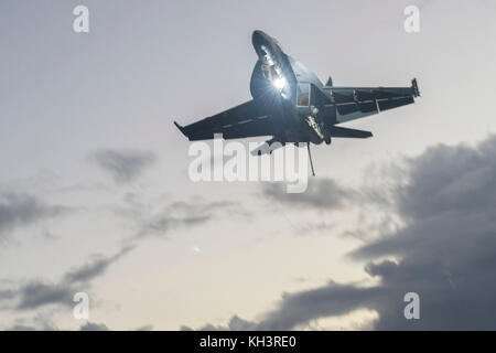 Un'F/A-18 Super Hornet vola sopra USS Nimitz CVN (68). La portaerei e il suo gruppo di sciopero sono Foto Stock