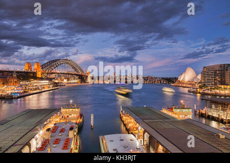 Occupato il porto di Sydney, illuminato al crepuscolo, alcune barche con motion blur. Foto Stock