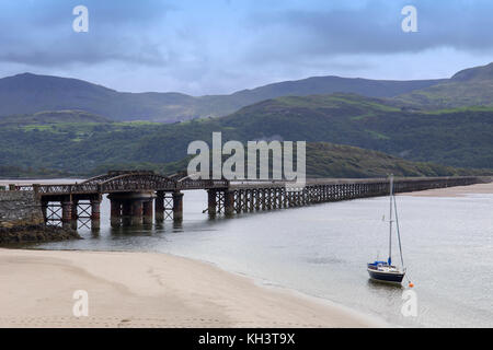 Blaenau Ffestiniog railway bridge over Mawddach Estuary per la Cambrian Coast linea ferroviaria, Snowdonia in distanza, Barmouth,Gwynedd,Galles,UK Foto Stock