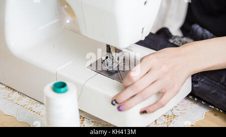 Close-up della macchina da cucire sul tavolo essendo filettato Foto Stock