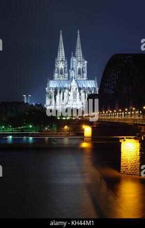 Cattedrale di Colonia e ponte di Hohenzollern durante la notte Foto Stock