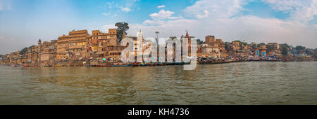 Varanasi india vista panoramica del fiume Gange banca con la città antica architettura edifici e barche di legno lungo il fiume ghats. Foto Stock