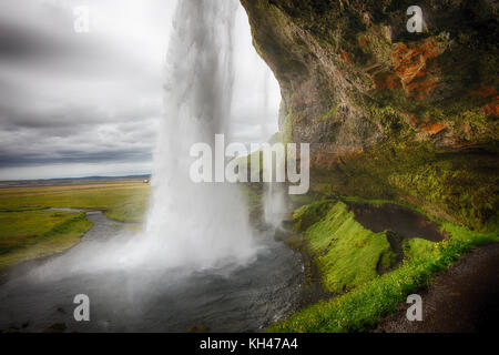 Vista della cascata seljalandafoss dietro da una grotta, Islanda Foto Stock