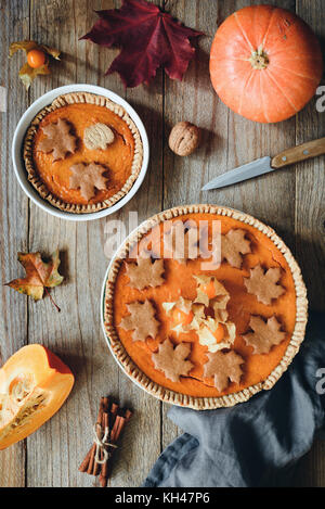 Fatti in casa Torte di zucca sul vecchio tavolo in legno. Vista superiore, verticale. La Giornata del ringraziamento cibo, autunno comfort food Foto Stock