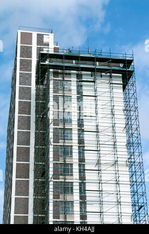 Underview del grattacielo alto edificio con i ponteggi Lavori di ristrutturazione contro blu cielo molto nuvoloso in Sud Africa Foto Stock