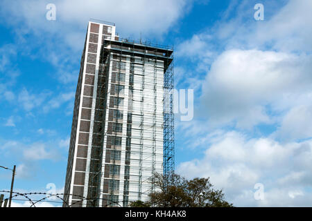 Underview del grattacielo alto edificio con i ponteggi Lavori di ristrutturazione contro blu cielo molto nuvoloso in Sud Africa Foto Stock