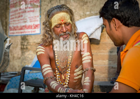 Varanasi sadhu uomo della predicazione di gioventù presso il Gange in riva al fiume varanasi india Foto Stock