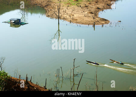 Due uomo che si muove velocemente in avanti su imbarcazione a motore come boat race, boat fa modello di onda sulla superficie acqua a nam ka lago, Dak Lak, Viet Nam Foto Stock