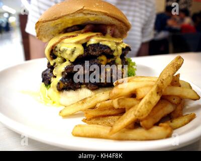 Foto di un grande panino hamburger e patatine fritte Foto Stock