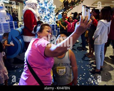 Pasig city, Filippine - 12 novembre 2017: i clienti prende un selfie davanti a un display di natale di uno stabilimento commerciale. Foto Stock