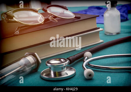 Libri di medicina accanto alle siringhe vintage e stetoscopio, concetto di medicina Foto Stock