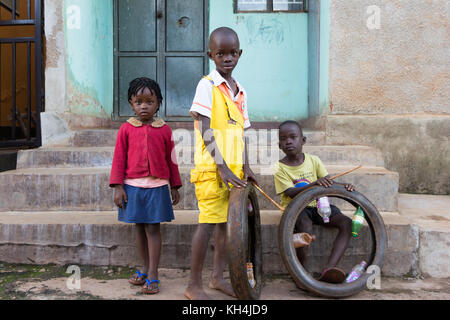 Bambini ugandesi giocando con un semplice giocattolo - un pneumatico di una motocicletta. Foto Stock