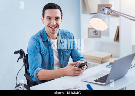 Ritratto di felice bruna che seduto al suo posto di lavoro Foto Stock