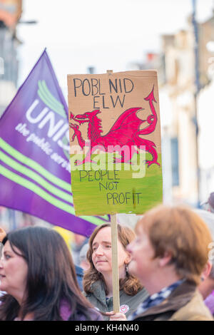 Achub / Salva Bodlondeb marcia di protesta e un gruppo di persone di tutte le età in marcia attraverso le strade di Aberystwyth Wales UK, portante Welsh bilingue Inglese/banner, per protestare contro il Ceredigion County Council piani per chiudere Bodlondeb, il locale la casa di cura per gli anziani, nel suo ultimo round di finanziamento di bilancio tagli. 16 settembre 2017 Foto Stock