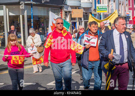 Achub / Salva Bodlondeb marcia di protesta e un gruppo di persone di tutte le età in marcia attraverso le strade di Aberystwyth Wales UK, portante Welsh bilingue Inglese/banner, per protestare contro il Ceredigion County Council piani per chiudere Bodlondeb, il locale la casa di cura per gli anziani, nel suo ultimo round di finanziamento di bilancio tagli. 16 settembre 2017 Foto Stock