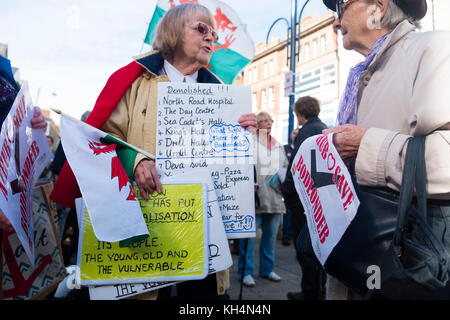 Achub / Salva Bodlondeb marcia di protesta e un gruppo di persone di tutte le età in marcia attraverso le strade di Aberystwyth Wales UK, portante Welsh bilingue Inglese/banner, per protestare contro il Ceredigion County Council piani per chiudere Bodlondeb, il locale la casa di cura per gli anziani, nel suo ultimo round di finanziamento di bilancio tagli. 16 settembre 2017 Foto Stock