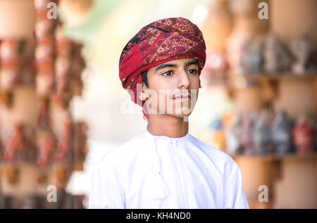 Ritratto di un giovane ragazzo dell'Oman in un abito tradizionale. Nizwa, Oman. Foto Stock