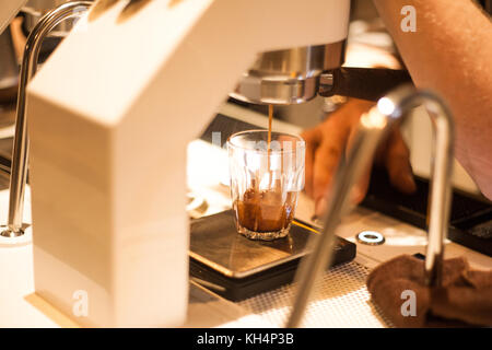 Barista brewing colpo espresso dalla macchina per espresso Foto Stock
