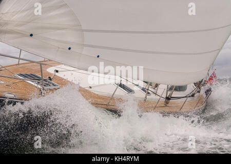 Close up della barca a vela, barca a vela o yacht di schiantarsi attraverso onde di un mare agitato Foto Stock