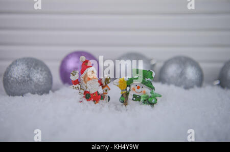 Colore fotografia natale immagine con tradizionale lieto carino babbo natale e pupazzo di neve ornamenti nella neve con tree ninnolo decorazioni in background Foto Stock