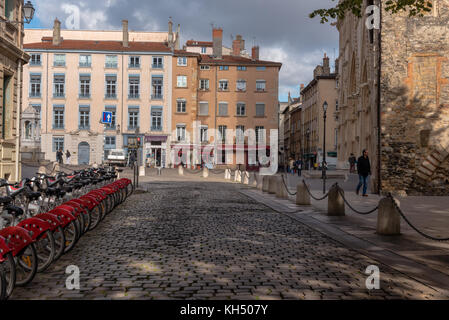 Lione, Francia -- Novembre 6, 2017 -- una fila di biciclette è parcheggiata da una strada di ciottoli che conducono a negozi e ristoranti nella città vecchia sezione di ly Foto Stock