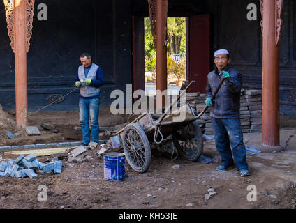 Dong Guan Gong casa essendo ristrutturato da lavoratori cinesi, provincia di Gansu, Linxia, Cina Foto Stock