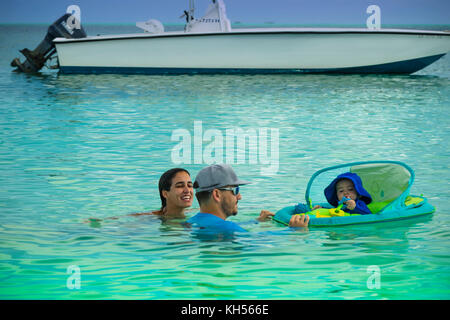 I genitori con un neonato sul brigantino beach, Treasure Cay, abacos, BAHAMAS Foto Stock